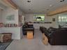 Living area with carpet flooring, beamed ceiling, and recessed lighting