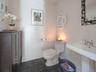Bathroom with dark tile patterned floors and toilet