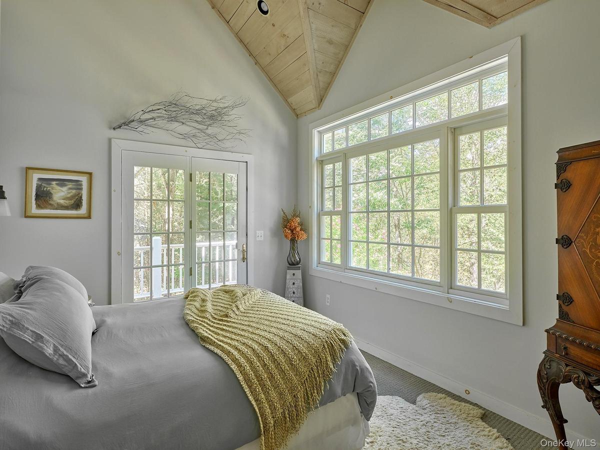 Carpeted bedroom featuring access to exterior, lofted ceiling, and wooden ceiling
