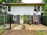 Back of House with door to basement and fencing