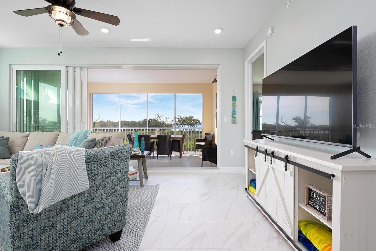 open floor plan, with wall to wall slider to screened in Lanai and waterfront bay and sunset views