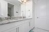 primary bath with double vanities and linen closet