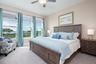 large primary suite with lots of windows and natural light and bay views