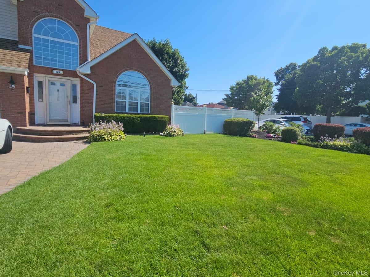 Brick exterior with a prominent arched window and a paver driveway