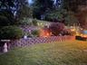 Terraced landscaping featuring retaining walls, mature shrubs, and planted beds