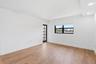 Wood-finish flooring, white painted walls, recessed lighting, French-style door, and a horizontal window with blinds