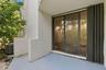 Patio with sliding glass doors, accordion hurricane shutters, and an air conditioning unit