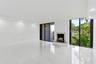 Spacious interior featuring white tile flooring, recessed lighting, and a white marble fireplace
