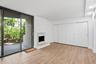 Wood-finish flooring, sliding glass patio door, marble-surround fireplace,