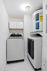 Dedicated utility area with a top-load washing machine, front-load dryer, and overhead cabinetry