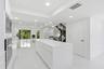 Open-concept kitchen with a large island, integrated stainless steel appliances, recessed ceiling lighting, and hard-surface flooring