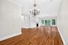 Hardwood flooring, crown molding, built-in shelving, fireplace, and sliding glass doors