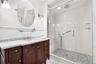 Shower with frameless glass enclosure, rain showerhead, and subway tile surround