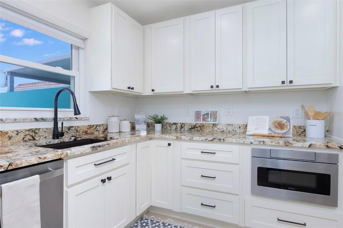Another view to show the functional kitchen. Window look out to the paved larage courtyard.