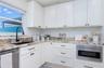 Another view to show the functional kitchen. Window look out to the paved larage courtyard.