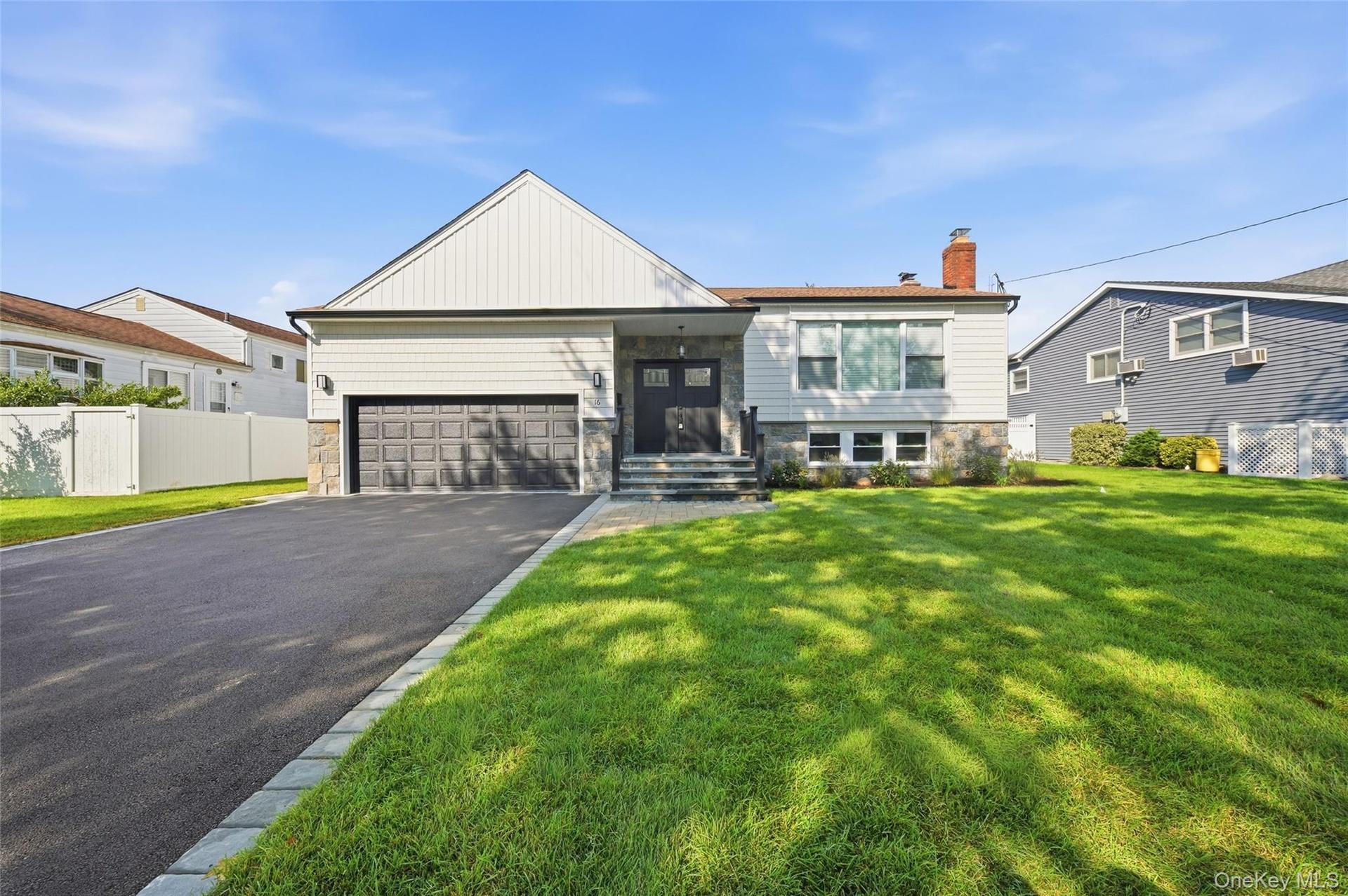 Contemporary exterior with a stone facade, a two-car garage, and a paved driveway