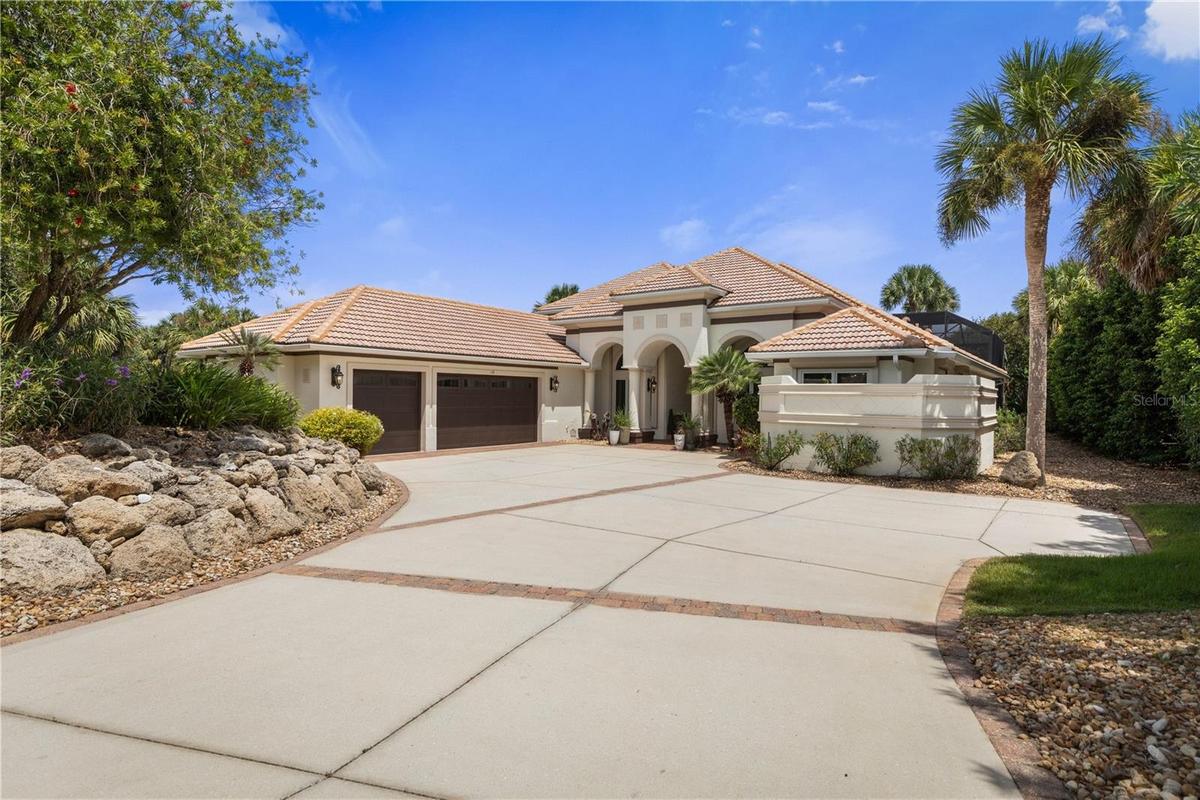 A grand welcome to 113 Island Estates Pkwy, where mature tropical landscaping and timeless architecture set the stage for the waterfront lifestyle wai