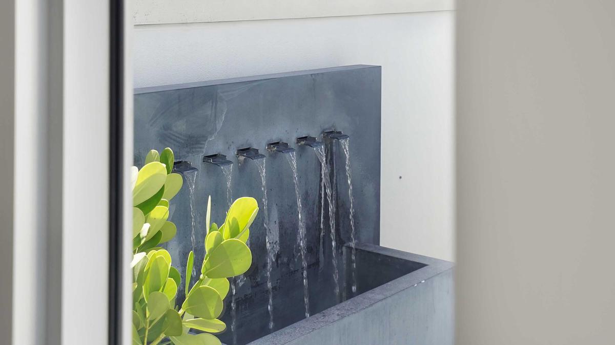 An integrated water feature introduces texture and movement to the outdoor setting.