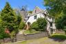 The 1929 Stockbroker Tudor reveals another side of its character—steep gables, a substantial stone chimney, slate roof and mature landscaping frame th