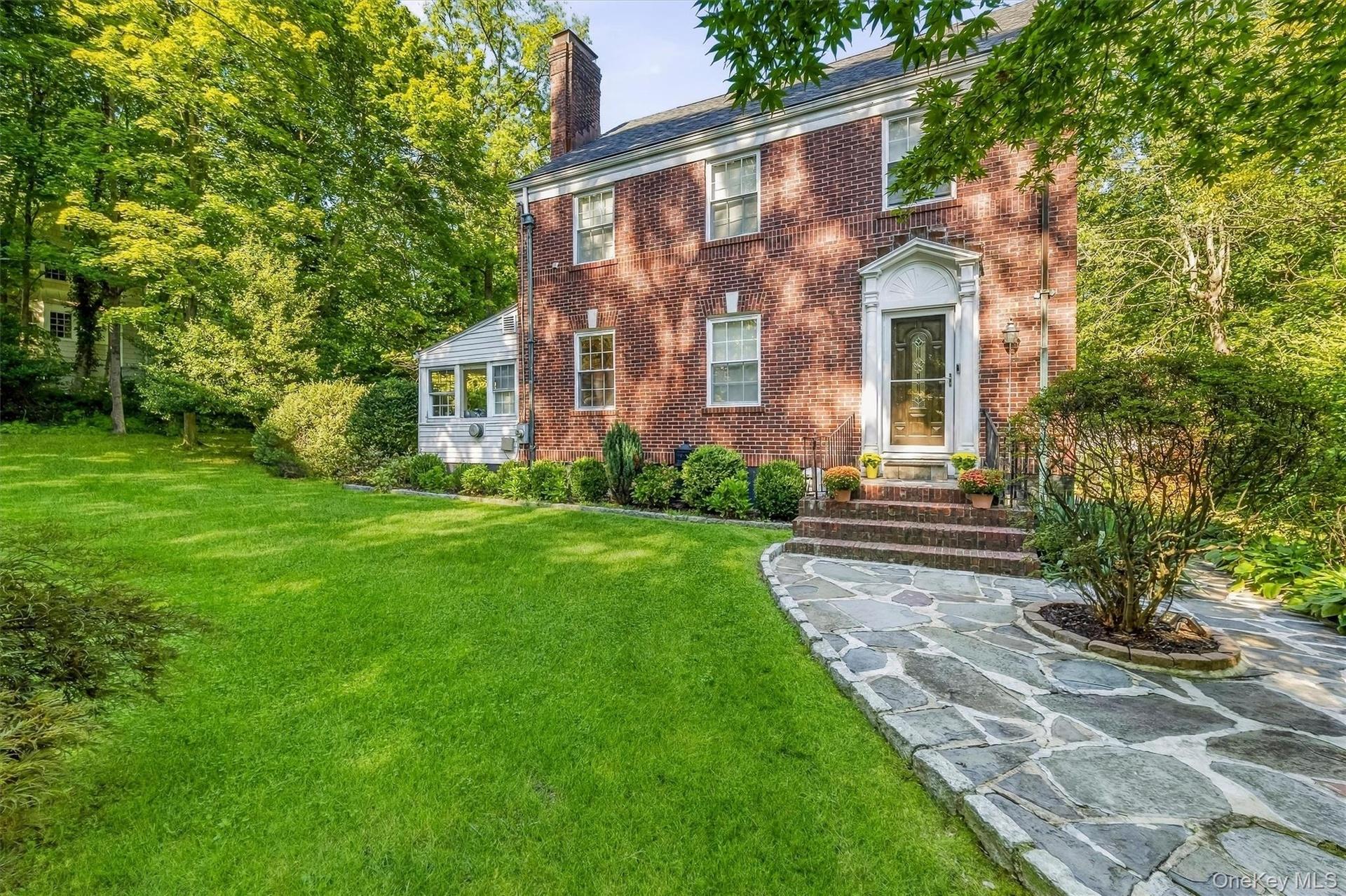 Brick exterior with a prominent chimney and a stone pathway leading to the entry