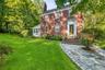 Brick exterior with a prominent chimney and a stone pathway leading to the entry