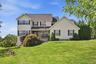 Two-story residence featuring light-colored siding and stone accents