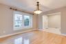 Hardwood flooring, recessed window, classic chandelier, arched entryway, and tile flooring