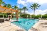 Resort style pool with lounge chairs, cabanas and BBQs