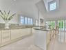 Volume Ceilings, French Doors, Wall of Windows and Dormers bring Natural Light into the Kitchen all day