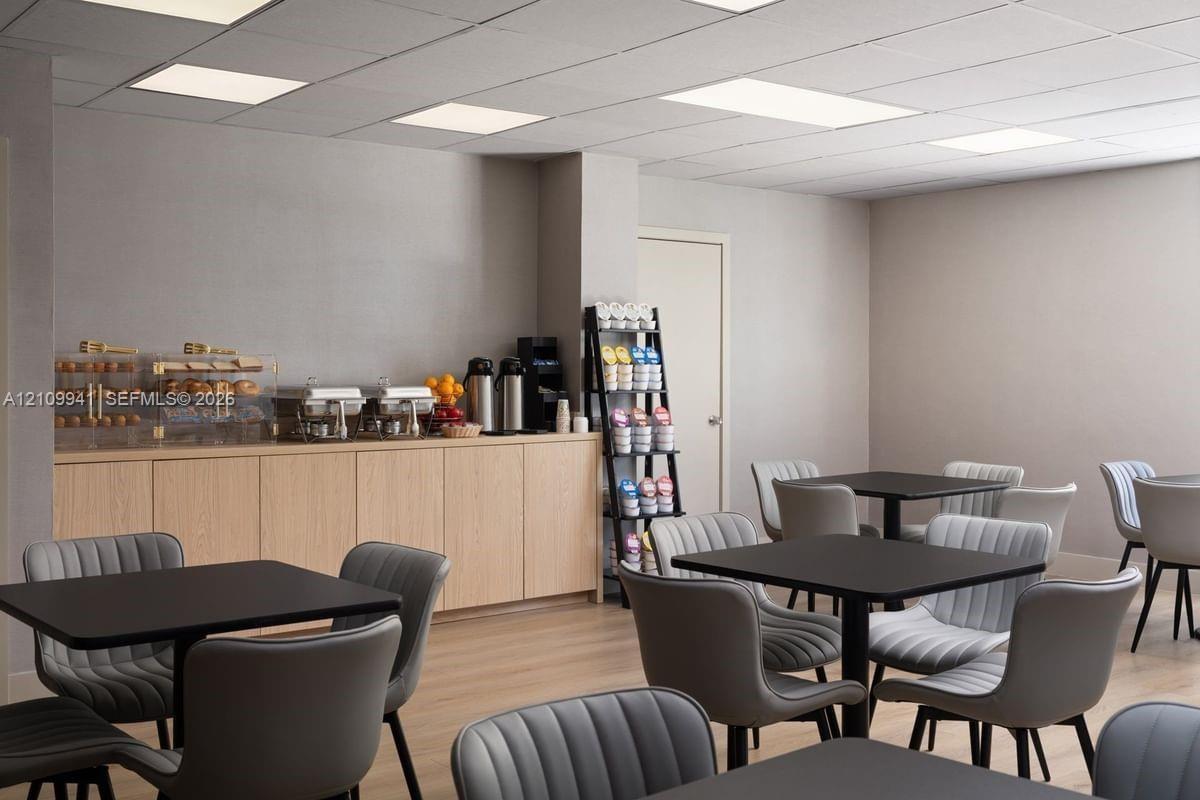 Built-in light-tone wood cabinetry, recessed ceiling lighting, and wood-finish flooring