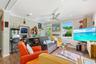 Living area featuring recessed lighting, a ceiling fan, crown molding, wood-finish flooring, and a single-pane window