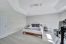 Tray ceiling, vertical paneling accent wall, and wood-finish flooring