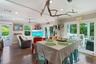 Open-concept floor plan featuring wood-finish flooring, recessed lighting, ceiling fan, and sliding glass doors opening to an exterior deck