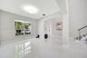 High-gloss tile flooring, arched architectural opening, multi-pane window, and staircase featuring a metal railing system
