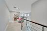 Open floor plan featuring wood-finish flooring, recessed lighting, and a metal horizontal-bar railing with a wood cap