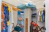 Walk-in closet featuring floor-to-ceiling metal wire shelving and integrated garment rods