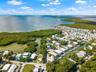 Aerial perspective showcasing waterfront access, direct proximity to open coastal waters, and extensive native mangrove vegetation