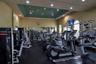Fitness center featuring a tray ceiling with recessed lighting, wall-to-wall mirrors, and arched windows