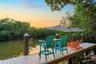 Waterfront dock featuring composite decking and anchored pilings surrounded by dense mature vegetation