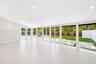 Open-concept interior featuring large-format tile flooring, recessed lighting, and expansive floor-to-ceiling glass panel doors