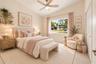 Vaulted ceilings, large picture window with natural light, multi-blade ceiling fan with integrated lighting, and two wall-mounted floating wood shelve