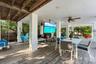 Covered patio featuring wood-finish flooring, recessed lighting, ceiling fans, and a ceiling-mounted television