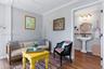 Interior space featuring wood-finish flooring and crown molding, with an opening to a bathroom equipped with a pedestal sink, three-bulb vanity lighti