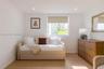 Neutral interior featuring wood-finish flooring, recessed lighting, and a window with a roller shade