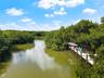 Private waterfront dock featuring wooden decking, sturdy pilings, and a covered pergola