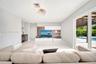 Large-format tile flooring, built-in media cabinetry with shelving, recessed lighting, and sliding glass doors leading to a covered patio with an outd