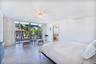 Full-height sliding glass doors with black metal framing, large-format tile flooring, recessed ceiling fixture, and glass-paneled interior door