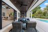 Covered lanai featuring a wood-plank ceiling, recessed lighting, ceiling fans, integrated outdoor kitchen, and multi-panel sliding glass doors opening