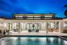 Covered outdoor living area featuring a metal roof, expansive glass door openings, built-in outdoor kitchen with cabinetry, integrated ceiling fans, a