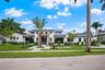 Contemporary residence featuring a clean-lined facade, multi-level roofline with metal roofing, stone veneer accent at the entryway, and expansive win
